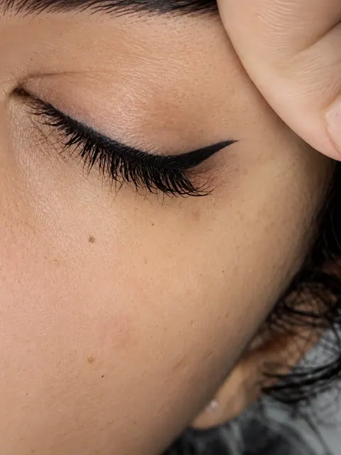 Gesloten oog met een verfijnde permanente eyeliner en een zachte wing
